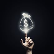 Human hand pointing with finger at money sign