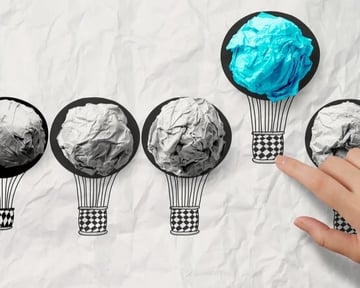hand drawn air balloons with blue crumpled paper ball as leadership concept